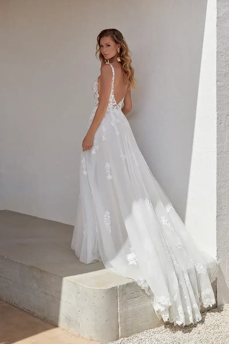model is wearing a sleeveless open back a-line wedding dress