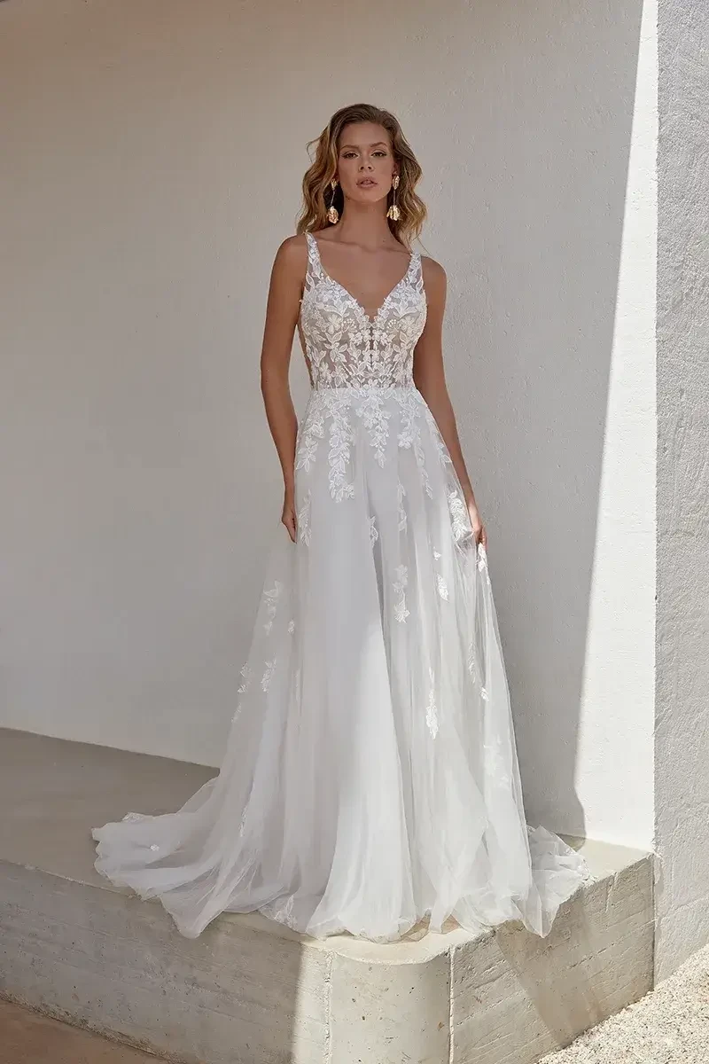 model is wearing a sleeveless open back a-line wedding dress