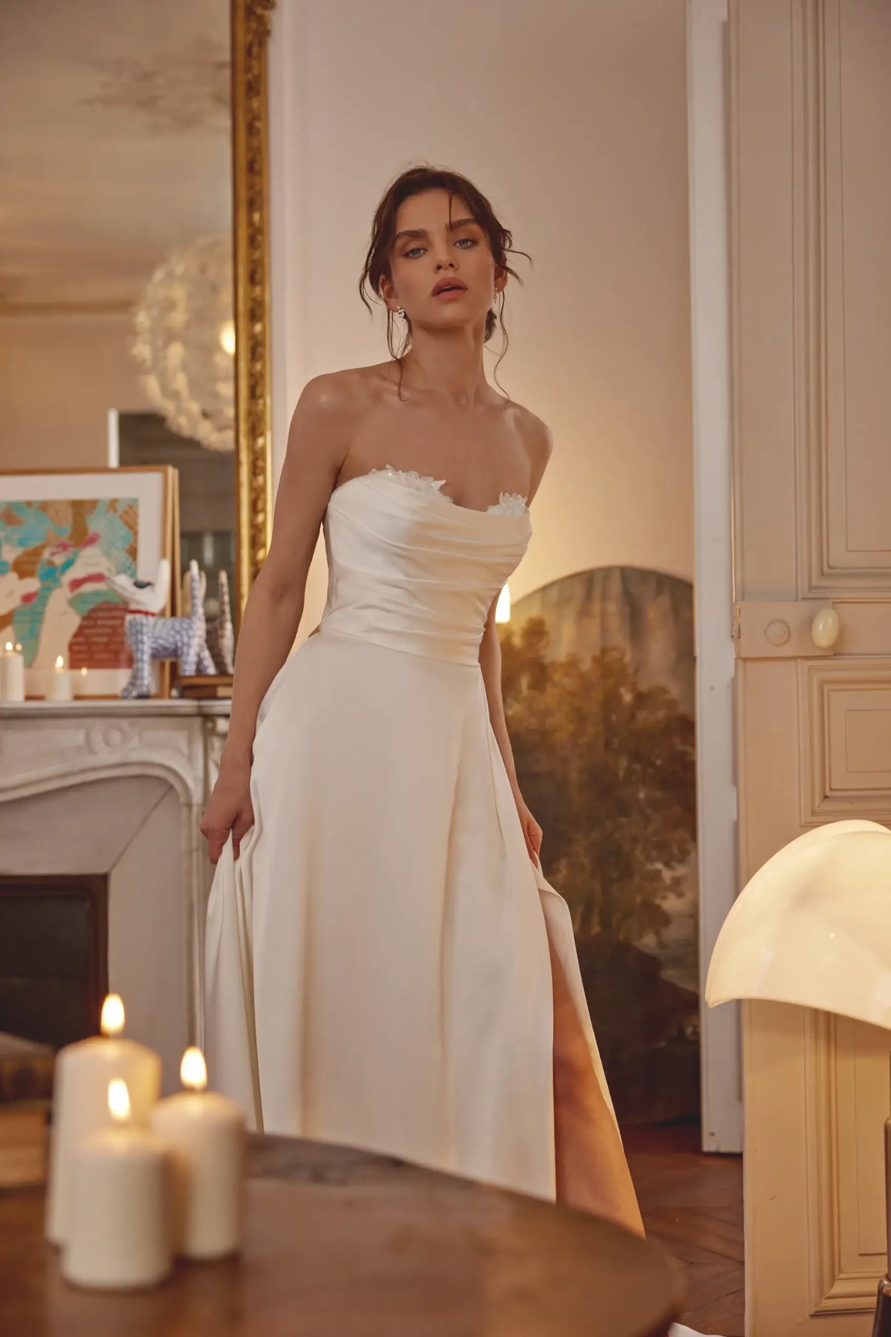 Model is wearing a charmeuse a-line bridal gown with a ruched sweetheart bodice