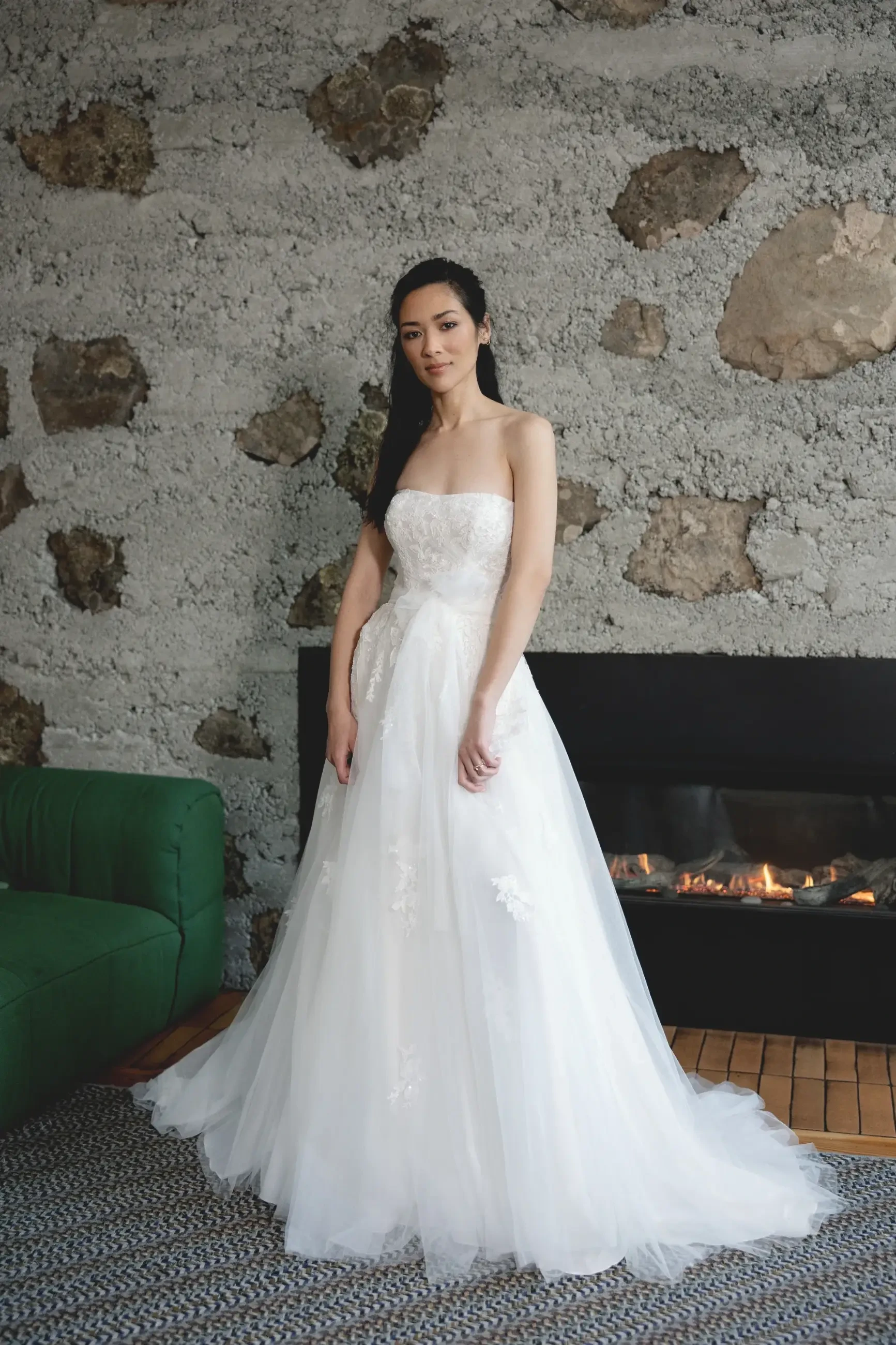 model is wearing a strapless a-line tulle wedding gown