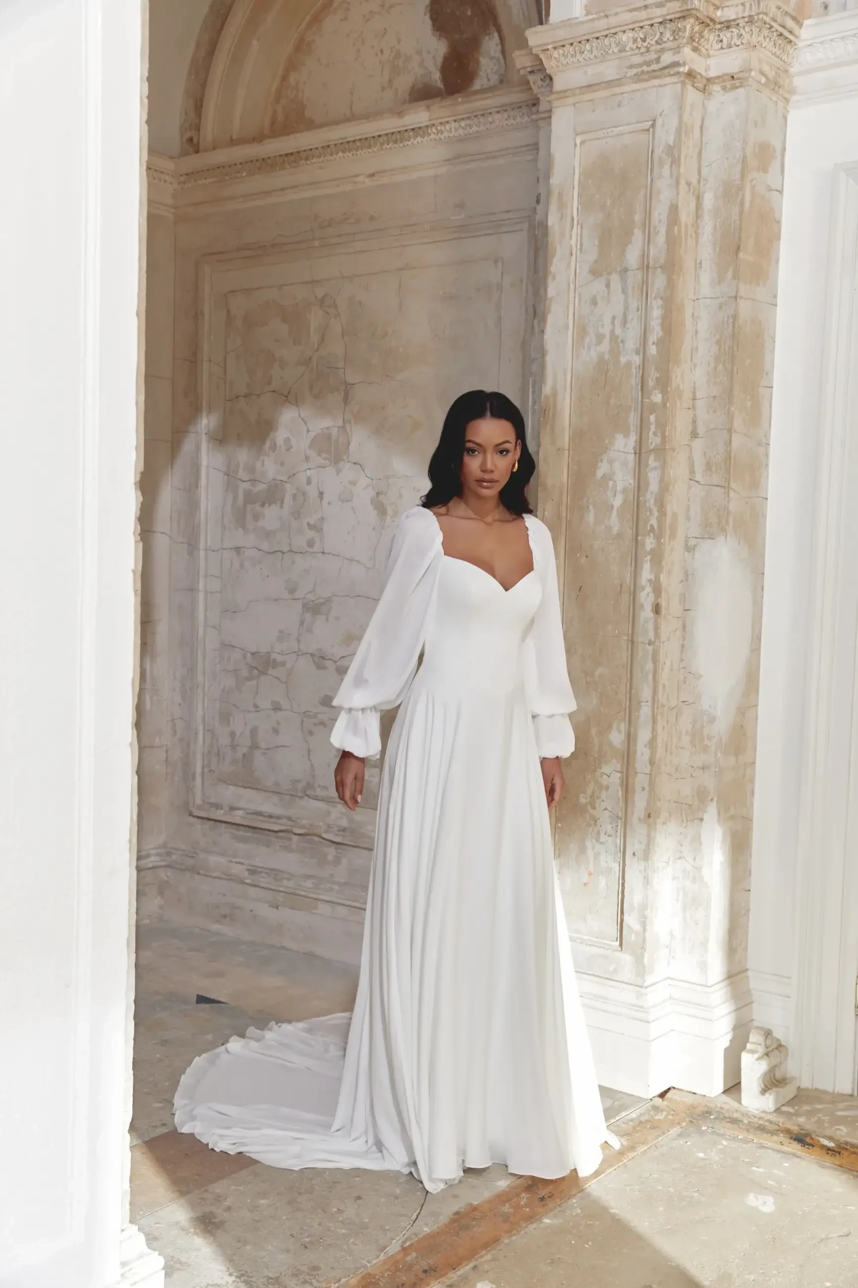 model is wearing a long sleeve a-line wedding dress with a sweetheart neckline