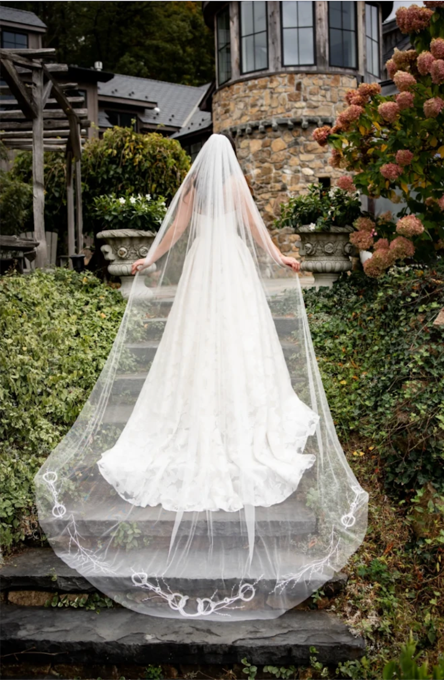 image shows a model wearing a cathedral length veil from the equestrian collection from lambs hill bridal